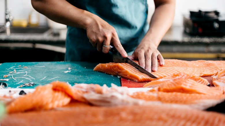 person cutting salmon