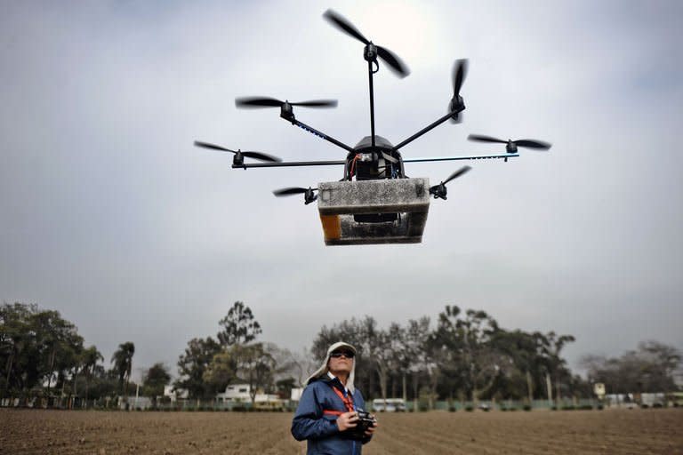 A man prepares to launch a drone in Lima, Peru on July 10, 2013. The unmanned aircraft are equipped with a microcomputer, a GPS tracker, a compass, cameras and an altimeter, and can be easily programmed by using Google Maps to fly autonomously and return to base with vital data