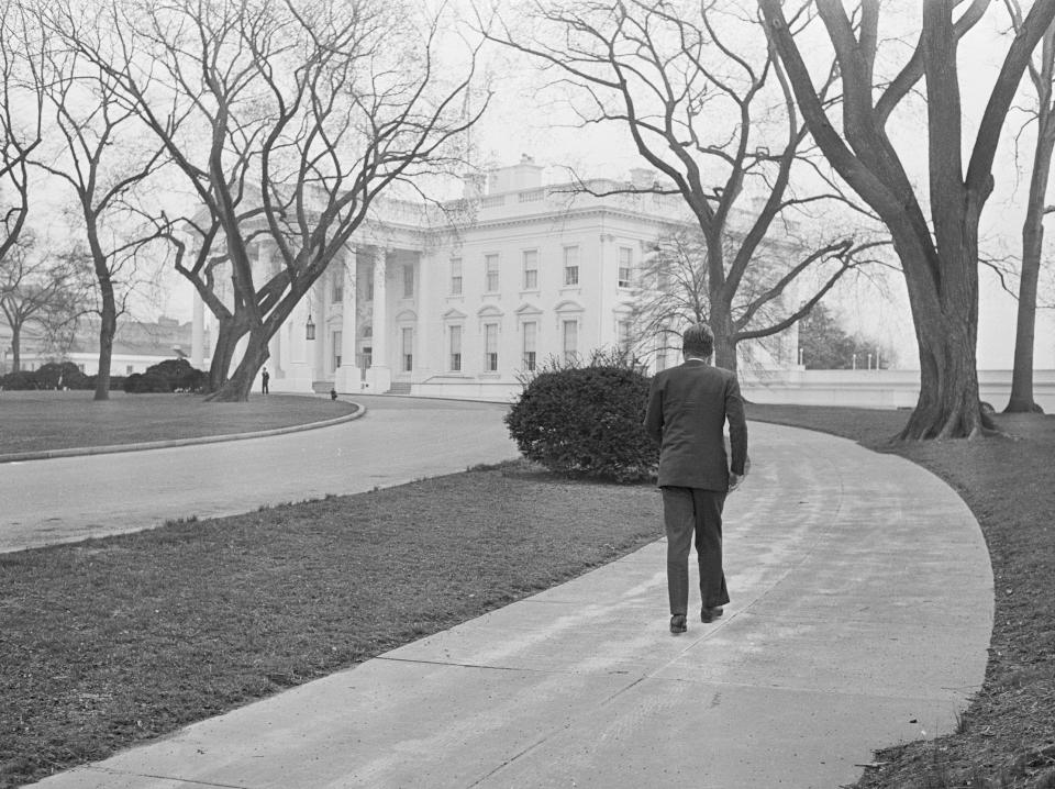 President John F. Kennedy walks along the circular walkway outside the White House after Sunday Mass in 1961.