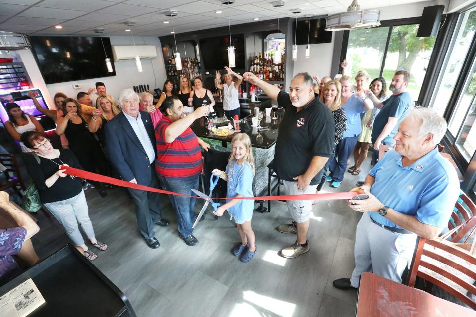 Hany Shhata (striped shirt) and Hakim Said ( dark shirt) lift their glasses with Greg Bistro's "Gregulars" during the reopening ceremony Wednesday, June 28, 2023.