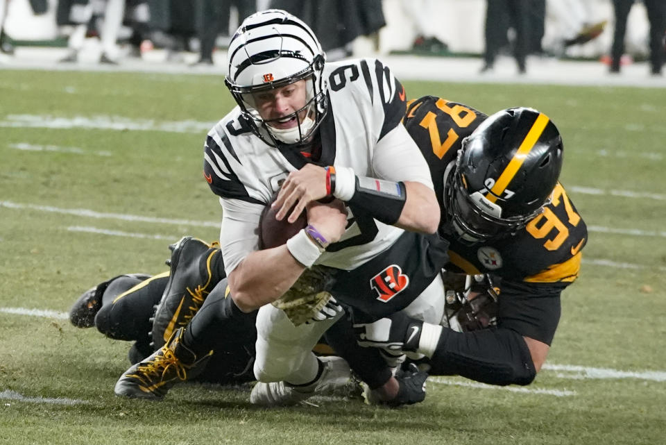Cincinnati Bengals quarterback Joe Burrow (9) is tackled by ]Pittsburgh Steelers defensive tackle Cameron Heyward (97) and safety Minkah Fitzpatrick (39) during the second half of an NFL football game, Sunday, Nov. 20, 2022, in Pittsburgh. (AP Photo/Gene J. Puskar)