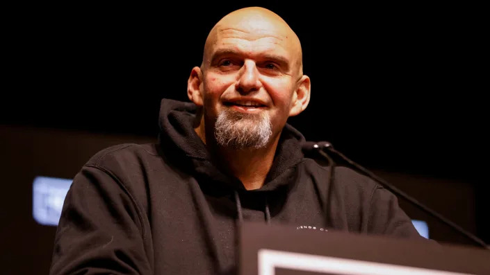 John Fetterman in trademark hoodie at the microphone.