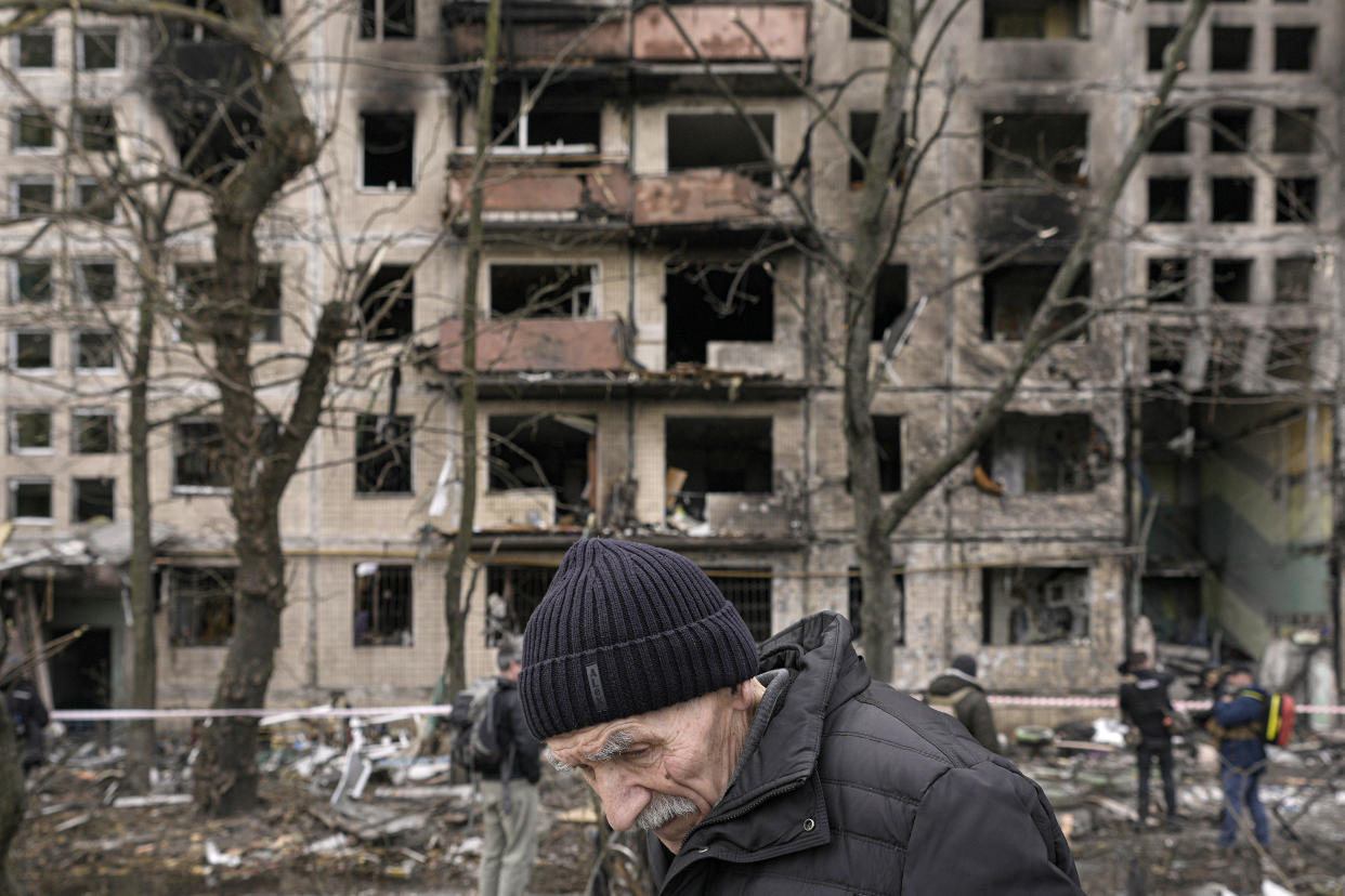 An elderly man walks outside an apartment block which was destroyed by an artillery strike in Kyiv, Ukraine, Monday, March 14, 2022. Russia's military forces kept up their punishing campaign to capture Ukraine's capital with fighting and artillery fire in Kyiv's suburbs Monday after an airstrike on a military base near the Polish border brought the war dangerously close to NATO's doorstep.(AP Photo/Vadim Ghirda)