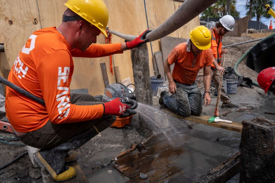 Archeologists carefully clean the hull of the vessel as crews map the exposed hull planking. The wreck was digitally and manually measured as it was exposed. Credit: Daniel Fiore (SEARCH, Inc.) & Florida Department of Transportation, District Two