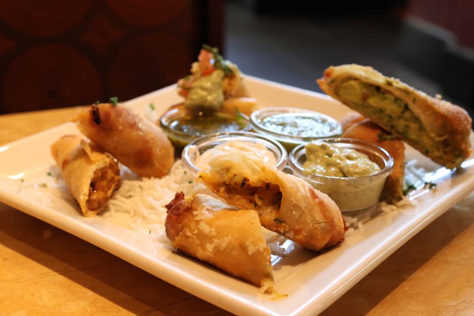 Four egg rolls in halves with dips in center on square plate at The Cheesecake Factory