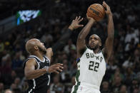 Milwaukee Bucks' Khris Middleton (22) shoots over Brooklyn Nets' Jevon Carter during the first half of an NBA basketball game Tuesday, Oct. 19, 2021, in Milwaukee. (AP Photo/Morry Gash)