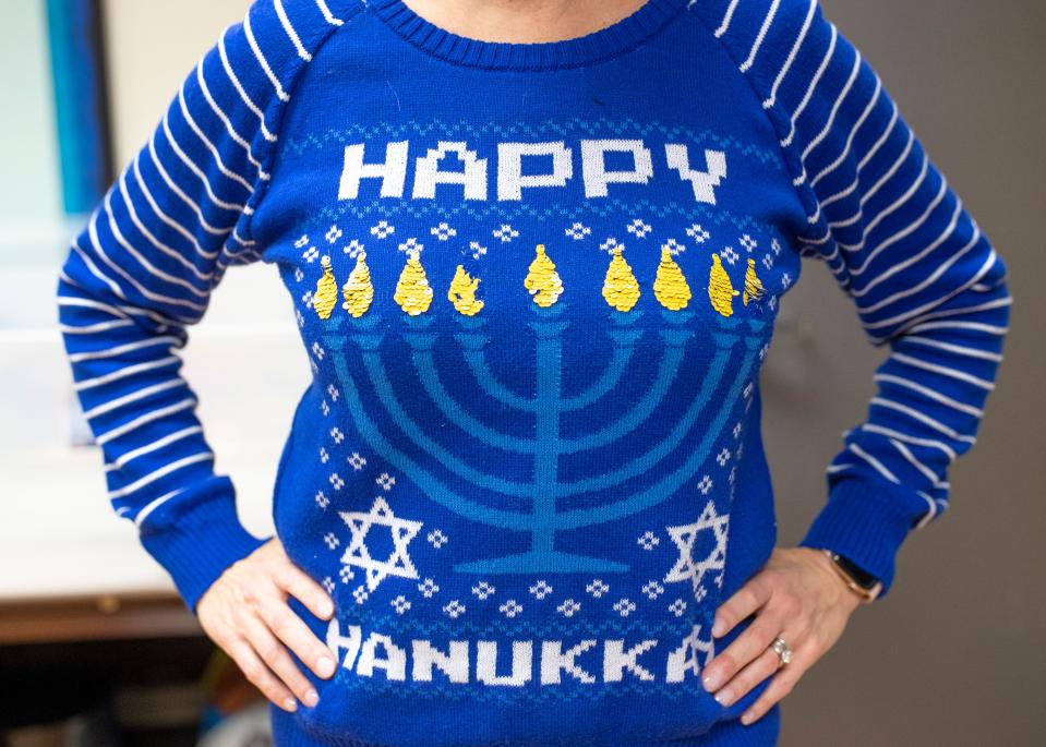 Alison Roemer, JCC's director of Jewish Journeys, wears a Happy Hanukkah shirt as she stuffs Hanukkah gift bags for pre-K, elementary, and middle school Jewish children Wednesday at the Jewish Community Center. Dec. 8, 2020