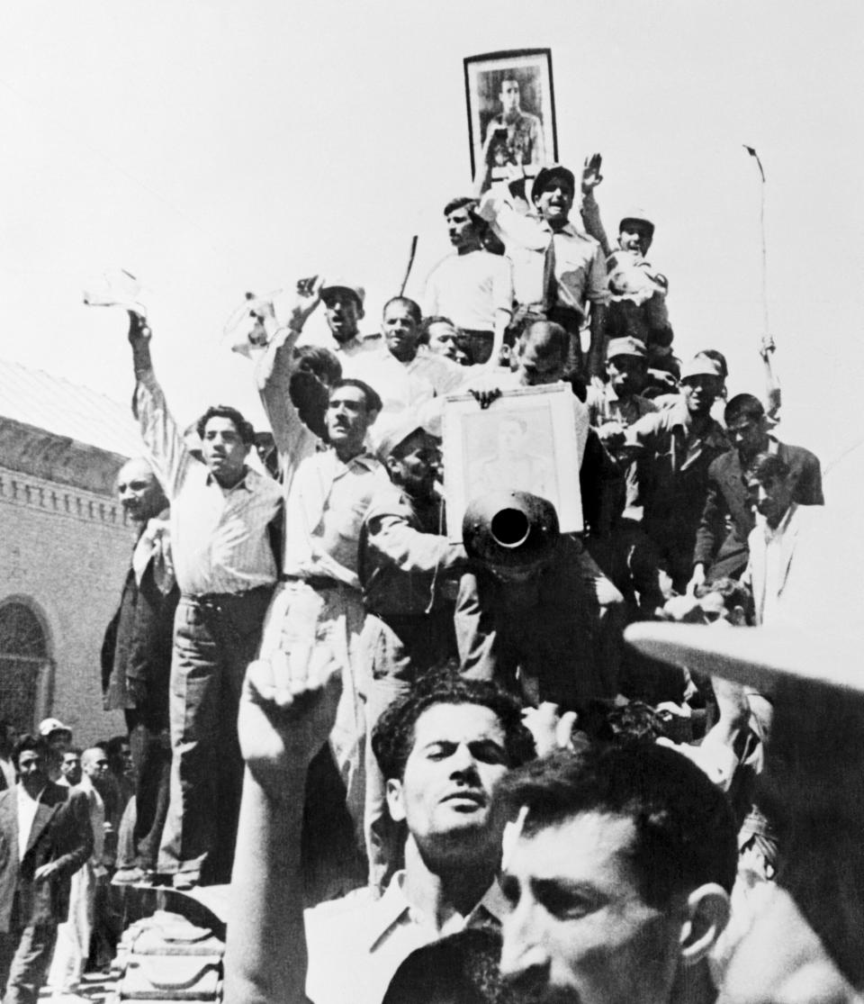 A portrait of the Shah is carried atop an Iranian Army tank patrolling the streets of Teheran after the coup that overthrew the regime of Premier Mohammed Mossadegh in 1953. | Bettmann Archive/Getty Images