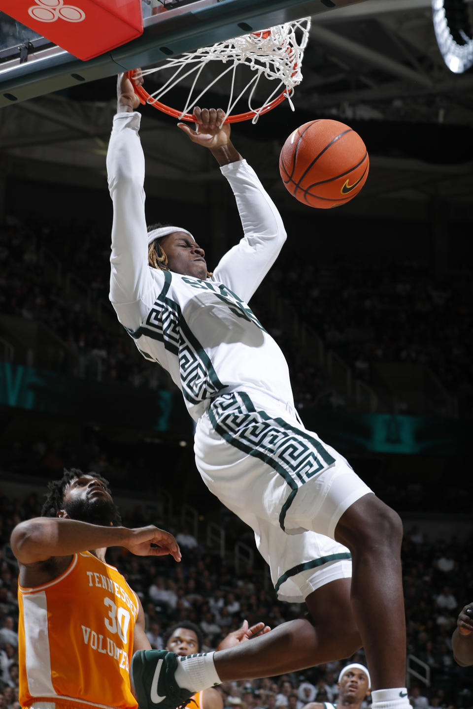 Michigan State's Coen Carr dunks off an alley-oop against Tennessee's Josiah-Jordan James (30) during the second half of an NCAA college basketball exhibition game, Sunday, Oct. 29, 2023, in East Lansing, Mich. Tennessee won 89-88. (AP Photo/Al Goldis)