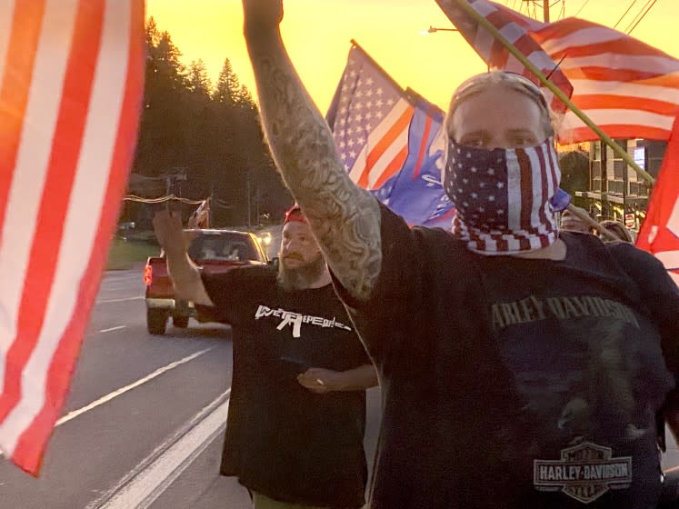 Supporters of President Donald Trump and police wave flags in Sandy, Ore.