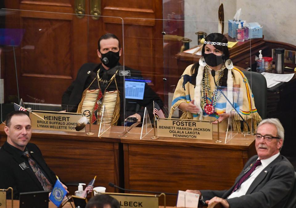 Senators Troy Heinert and Red Dawn Foster wear tribal regalia during the first legislative session of the season on Tuesday, January 12, at the South Dakota State Capitol in Pierre. Signs posted around the building stated that face masks were "encouraged," though not required, and lawmakers could request plexiglass panels in front of their desks as an optional added safety measure.