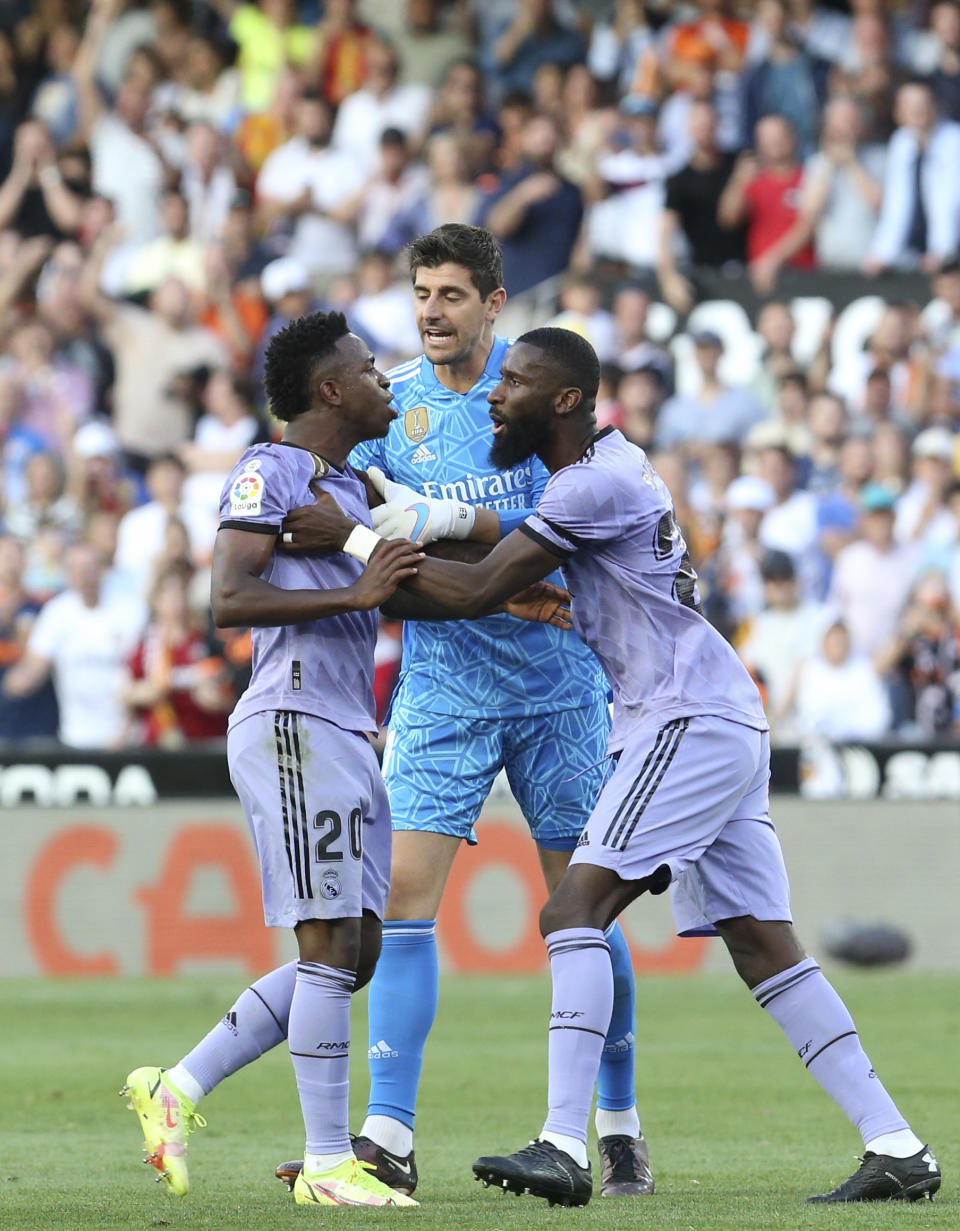 Real Madrid's goalkeeper Thibaut Courtois, centre and Antonio Rudiger, right, try to calm Vinicius Junior during a Spanish La Liga soccer match between Valencia and Real Madrid, at the Mestalla stadium in Valencia, Spain, Sunday, May 21, 2023. The game was temporarily stopped when Vinicius said a fan had insulted him from the stands. He was later sent off after clashing with Valencia players. (AP Photo/Alberto Saiz)