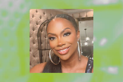 Kandi smiling in full glam and hoop earrings.