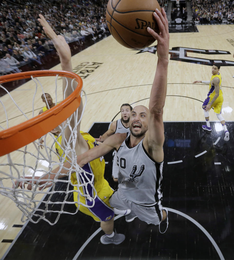 FILE - In this March 3, 2018, file photo, San Antonio Spurs guard Manu Ginobili (20) scores past Los Angeles Lakers center Ivica Zubac, left, during the second half of an NBA basketball game, in San Antonio. Ginobili retired at age 41 Monday after a "fabulous journey" in which he helped the San Antonio Spurs win four NBA championships in 16 seasons with the club.(AP Photo/Eric Gay, File)
