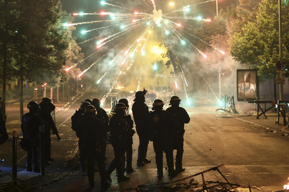 FILE - Police stand amid firecrackers on the third night of protests sparked by the fatal police shooting of a 17-year-old driver in the Paris suburb of Nanterre, France, Friday, June 30, 2023. France, especially white France, doesn't tend to frame discussion of discrimination and inequality in black-and-white terms. Some French consider it racist to even discuss skin color. No one knows how many people of various races live in the country, as such data is not recorded. (AP Photo/Aurelien Morissard, File)