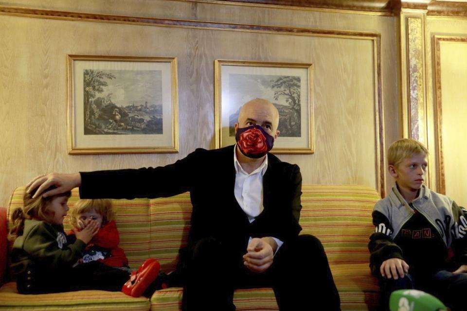 In this photo provided by the Albanian Prime Minister's office, Albania's Prime Minister Edi Rama sits at a hotel in Beirut, Lebanon, Monday, 26, 2020, with Albanian children as part of an operation to take them back home to Albania from Al Hawl, northern Syria. A few hundred Albanian men are known to have joined terror groups in Syria and Iraq in the early 2010s, and now many of them are dead and their family members are stuck in Syria camps, but will be repatriated via Beirut to Albania. (Albanian Prime Minister's office via AP)