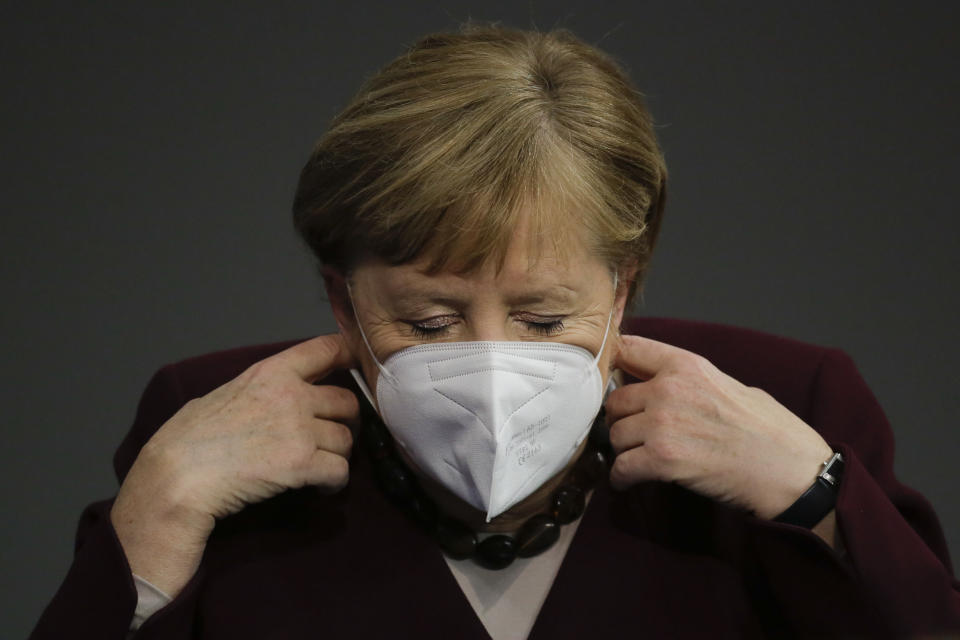 German Chancellor Angela Merkel adjusts her face mask as she arrives for a parliament session about German government's policies to combat the spread of the coronavirus and COVID-19 disease at the parliament Bundestag, in Berlin, Germany, Thursday, Nov. 26, 2020. Merkel and the country's 16 state governors have agreed to extend a partial shutdown well into December in an effort to further reduce the rate of coronavirus infections ahead of the Christmas period. (AP Photo/Markus Schreiber)