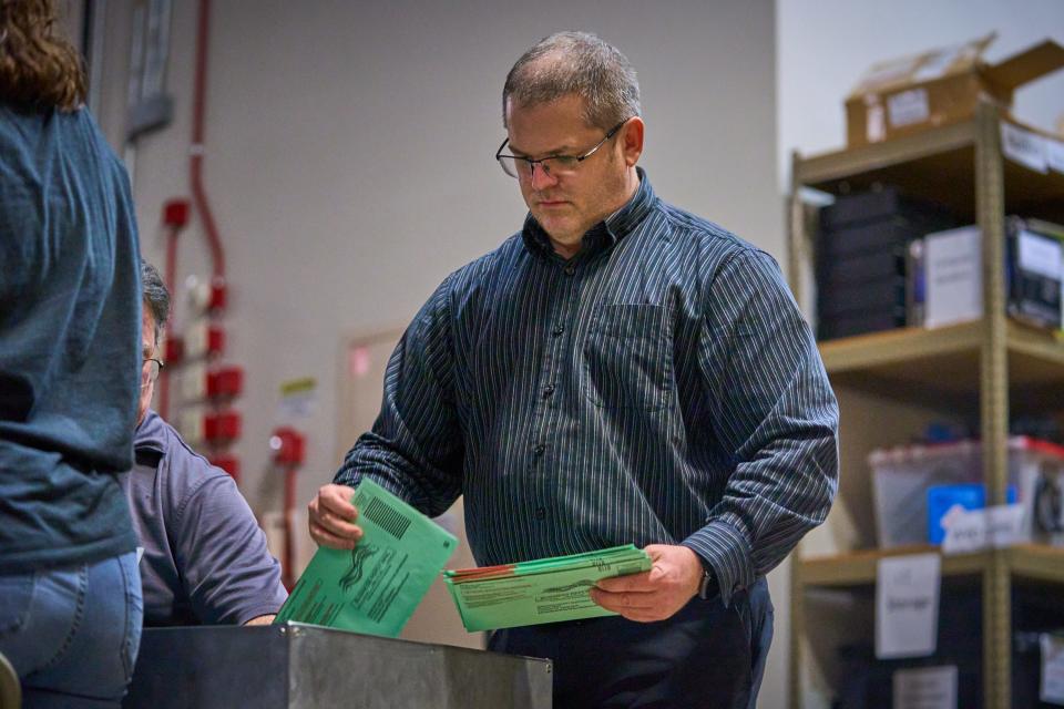 Election workers sort mail-in ballots for processing inside Maricopa County Tabulation and Election Center in Phoenix on Nov. 8, 2022. County officials referred to this process as "Red Line Blue Line."