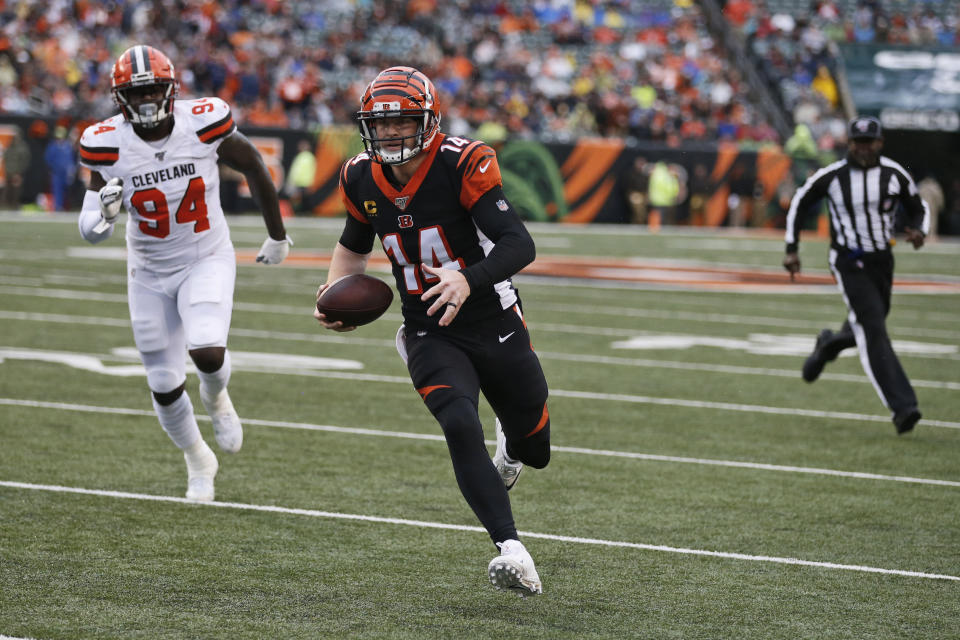 Cincinnati Bengals quarterback Andy Dalton (14) rushes for a 5-yard touchdown during the first half of an NFL football game against the Cleveland Browns, Sunday, Dec. 29, 2019, in Cincinnati. Browns defensive end Bryan Cox (94) watches. (AP Photo/Gary Landers)