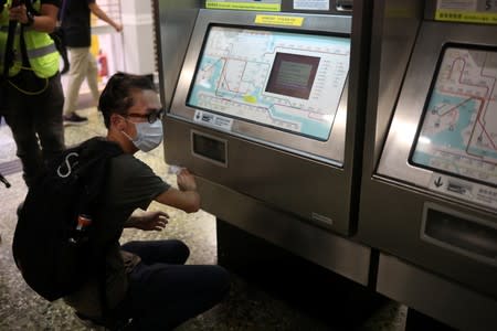 Supporter of the anti-extradition bill cleans the ticket machine as part of the Sham Shui Po Station Cleaning Campaign in Hong Kong