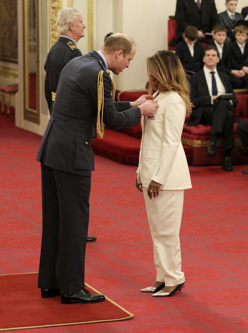 Rapper and singer MIA, real name Mathangi Arulpragasam, is made an MBE by Prince William Duke of Cambridge, left, at Buckingham Palace, in London, Tuesday Jan. 14, 2020. The honorary award is conferred in recognition of contributions to the arts, sport, sciences, and charitable works. (Jonathan Brady/PA via AP)