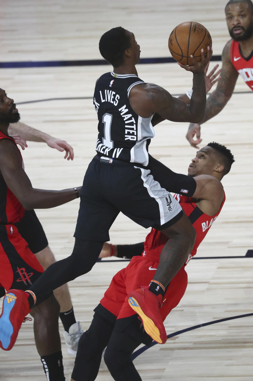 San Antonio Spurs guard Lonnie Walker IV (1) runs into Houston Rockets guard Russell Westbrook (0) while attempting a shot, resulting in an offensive foul during the second half of a NBA basketball game Tuesday, Aug. 11, 2020, in Lake Buena Vista, Fla. (Kim Klement/Pool Photo via AP)