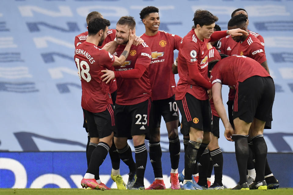 Manchester United's Luke Shaw celebrates with Bruno Fernandes, left, after scoring his side's second goal during the English Premier League soccer match between Manchester City and Manchester United at the Etihad Stadium in Manchester, England, Sunday, March 7, 2021. (Peter Powell/Pool via AP)