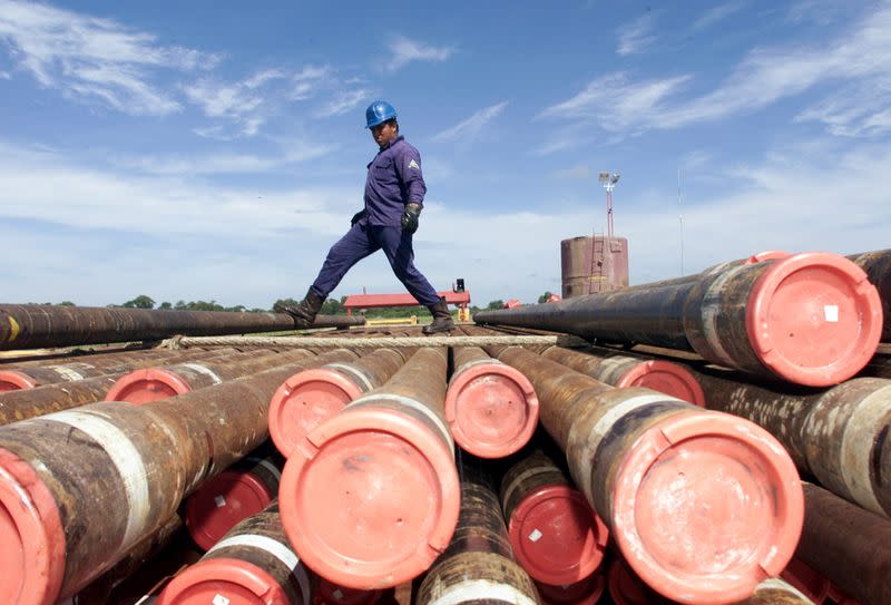 FILE PHOTO: An oil worker with Mexico's state owned oil company, PEMEX (Petroleos de Mexico), kicks a drilling r..