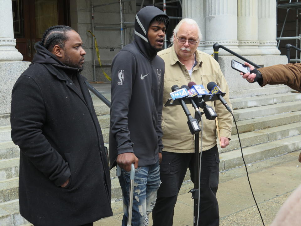 In this Nov. 29, 2018 photo, Jerry Smith speaks during a news conference in front of the federal courthouse in Milwaukee. Shot by police in August 2017, his right leg is partially paralyzed. Smith wasn't charged with a crime and has a pending federal lawsuit against the police, alleging officers acted "with deliberate indifference." "I had my hands up. It's on them," Smith says. At left is Tory Lowe, a community activist supporting Smith’s cause, and at right is Daniel Storm, a private investigator working on Smith’s case. (AP Photo/Ivan Moreno)