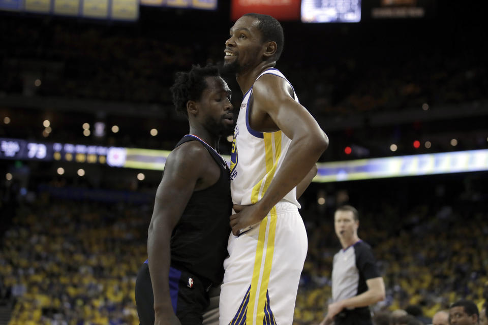 Golden State Warriors' Kevin Durant, right, smiles as Los Angeles Clippers' Patrick Beverley guards him during the second half in Game 1 of a first-round NBA basketball playoff series Saturday, April 13, 2019, in Oakland, Calif. (AP Photo/Ben Margot)