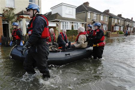 Police specialist search team rescues Archie (3rd L) and Dorothy Doye (3rd R) from their home which was surrounded by flood water at Egham after the River Thames burst its banks in south east England February 13, 2014. REUTERS/Luke MacGregor
