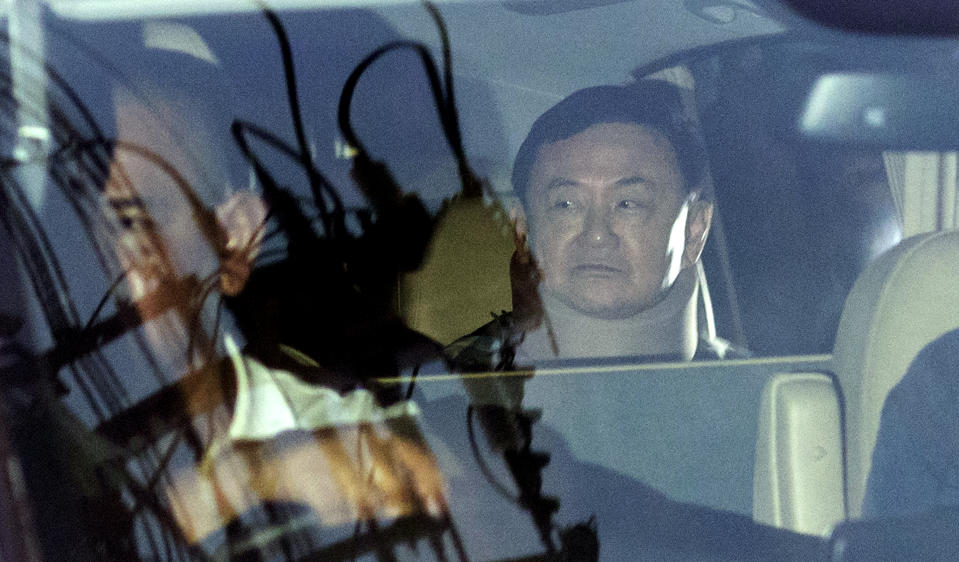 Former Thai Prime Minister Thaksin Shinawatra, right, sits in a vehicle in front of his residence after being released on parole, Sunday, Feb. 18, 2024, in Bangkok, Thailand. Thaksin was released from Police General Hospital where for the last six months he had been serving time for corruption-related offenses. (AP Photo/Wason Wanichakorn)