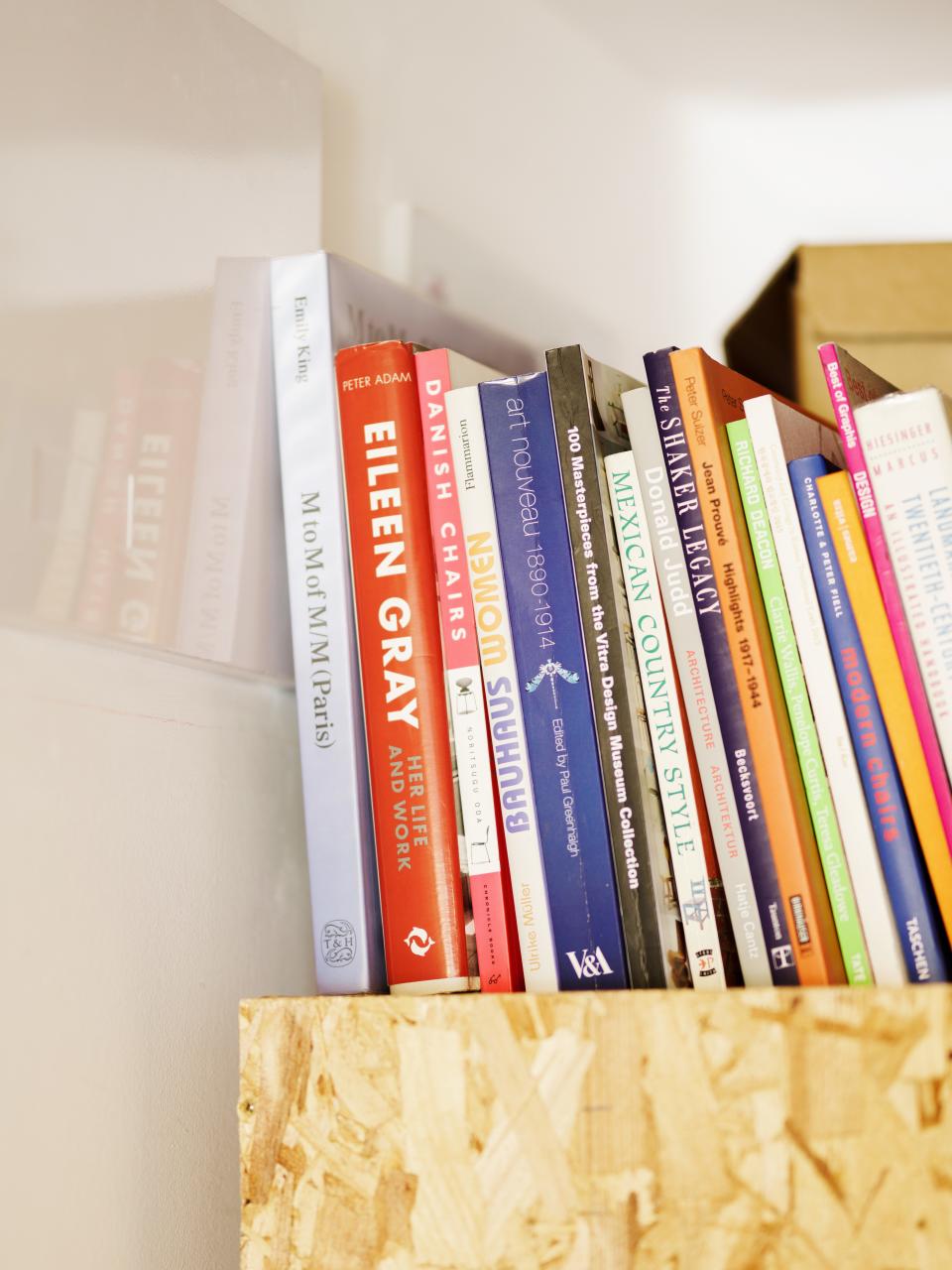 Colorful books on plywood shelves.