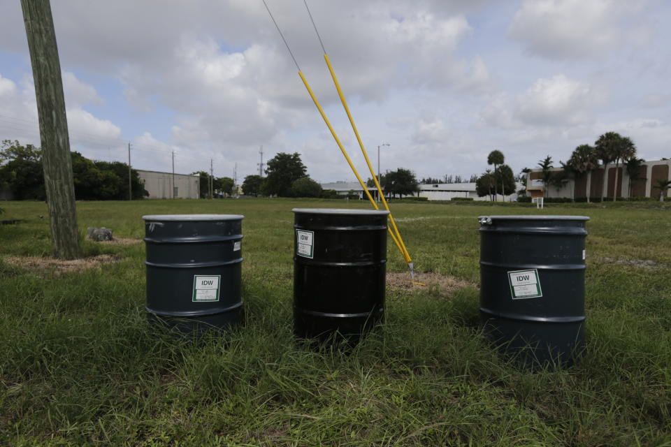 FILE - In this Sept. 6, 2017 file photo, barrels identified by stickers as IDW, or "investigation derived waste," full of soil and water, sit in a field designated by the EPA as an intensely polluted Superfund site called Anodyne North Miami Beach. Tens of billions of dollars for U.S. environmental justice initiatives originally proposed in a $3.5 trillion domestic spending package now hang in the balance as Democrats decide how to trim the bill down to $2 trillion in October 2021. (AP Photo/Jason Dearen, File)