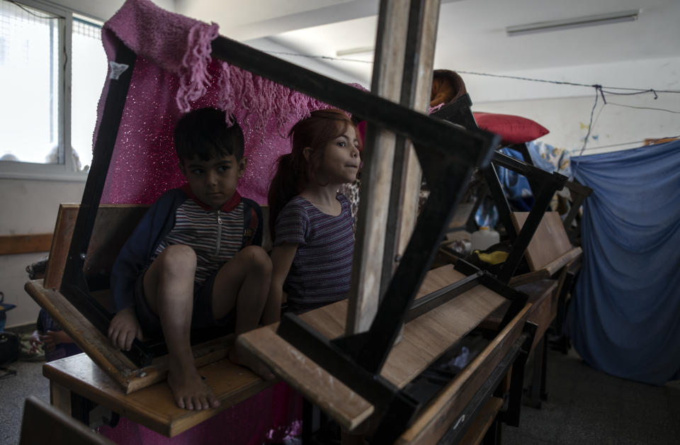 Palestinians take shelter at a school run by the U.N. after fleeing heavy Israeli missile strikes in the outskirts of Gaza City, Wednesday, May 19, 2021. The Gaza Strip's already feeble health system is being brought to its knees by the fourth war in just over a decade. At the school, no one wore a mask or could do any social distancing in the cramped quarters. (AP Photo/Khalil Hamra)