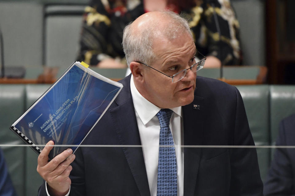 Australia's Prime Minister Scott Morrison holds a government document outlining emissions reductions at the parliament house in Canberra, Wednesday, Oct. 27, 2021. Australia's opposition party said a looming election will be fought on greenhouse gas reduction targets as Morrison comes under criticism from scientists over the modest goals he will take to a U.N. climate summit. (Mick Tsikas/AAP Image via AP)