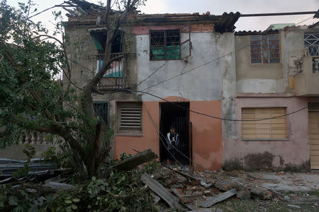 A boy stands in the door of his home after a tornado ripped through a neighbourhood, in Havana, Cuba January 28, 2019. REUTERS/Fernando Medina