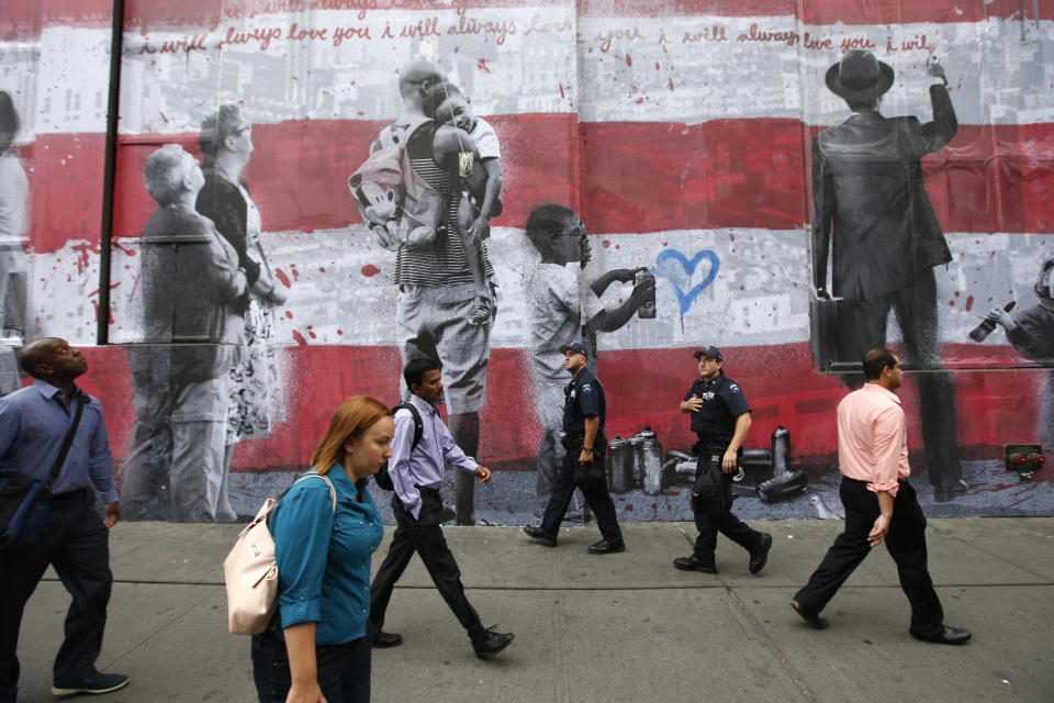 Police officers, rear, patrol a few blocks from the National September 11 Memorial at the World Trade Center site before a ceremony marking the 13th anniversary of the Sept. 11, 2001 attacks, Thursday, Sept. 11, 2014, in New York. (AP Photo/Jason DeCrow)