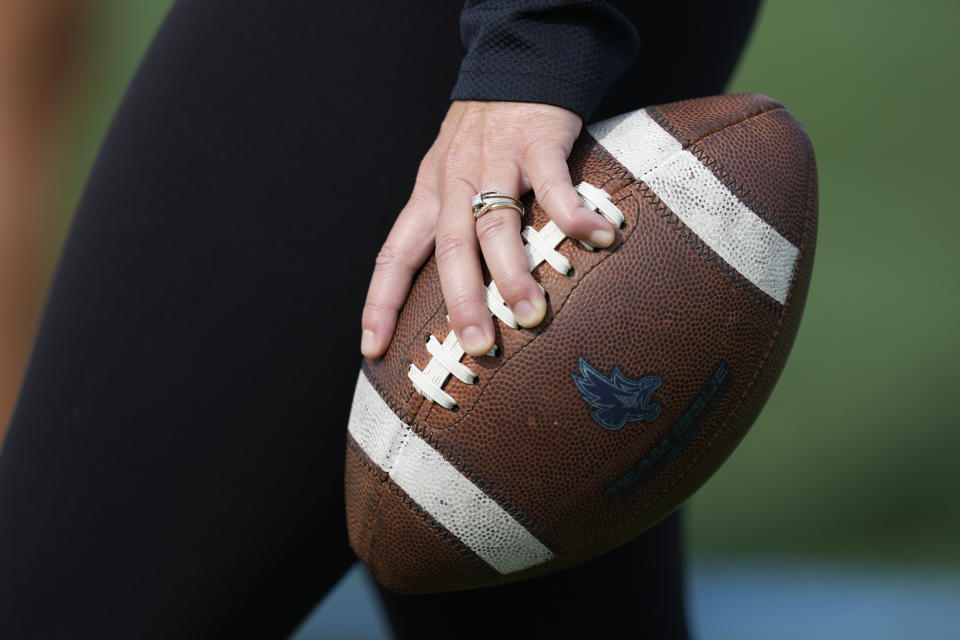 An assistant coach holds a football during a training session for Keiser University's flag football team in West Palm Beach, Fla., Thursday, Nov. 30, 2023. The no-contact sport featuring plenty of offensive action has really been on the rise for a while, with girls-specific teams and leagues springing up from coast to coast. (AP Photo/Rebecca Blackwell)