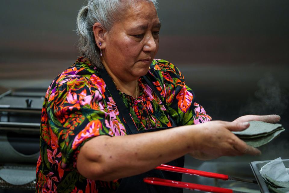 Yolanda Rosas, mother of Esteban Rosas, a co-owner at Taqueria de Julieta, bare-hands hot-off-the-grill blue corn tortilla Wednesday, Aug. 9, 2023, prior to opening. 