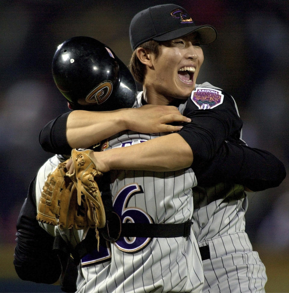 FILE - Arizona Diamondbacks pitcher Byung-Hyun Kim, right, smiles as he celebrates with catcher Damian Miller after pitching the final out against the Altanta Braves in Game 5 of the National League Championship Series at Turner Field in Atlanta, on Oct. 21, 2001. (AP Photo/John Bazemore, File)