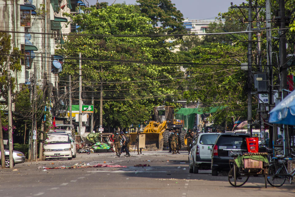 Soldiers and police use a bulldozer to remove improvised barricades installed by anti-coup protesters and residents to secure a neighborhood from security forces in Yangon, Myanmar Thursday, March 18, 2021. (AP Photo)