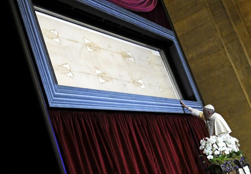 FILE PHOTO: Pope Francis touches the Shroud of Turin during a two-day pastoral visit in Turin