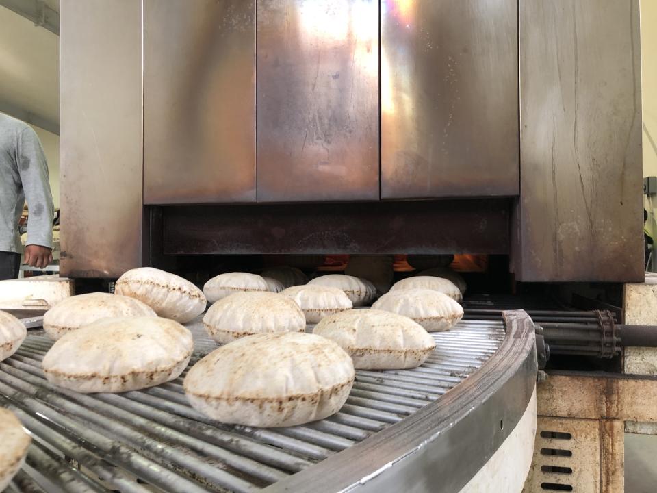 The rotis coming out the oven at the onsite factory