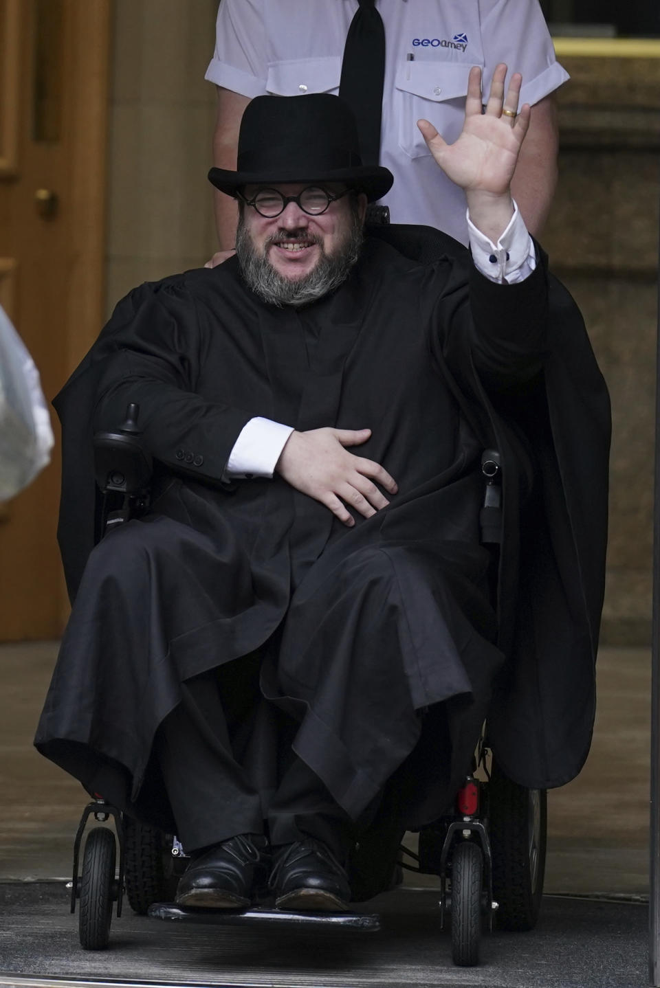 Nicholas Rossi from he U.S. waves as he leaves the Edinburgh Sheriff and Justice of the Peace Court in Edinburgh, Scotland, Wednesday, July 12, 2023. An American fugitive accused of faking his own death to avoid a rape charge has been ordered by a judge in Scotland to be returned to the U.S. The man known as Nicholas Rossi was ordered extradited Wednesday after fighting the case for nearly two years. (Andrew Milligan/PA via AP)