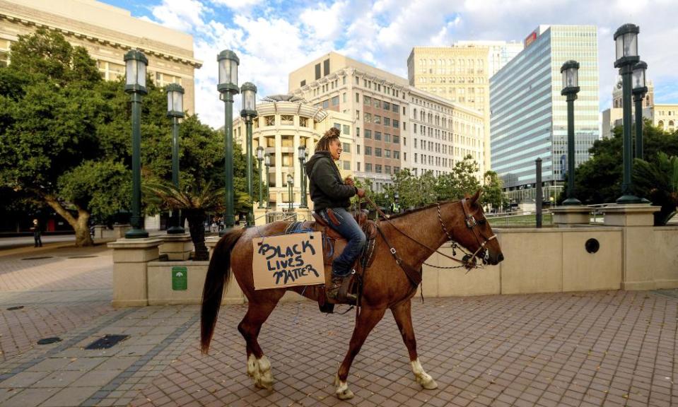 Brianna Noble rides Dapper Dan through downtown Oakland on Friday.