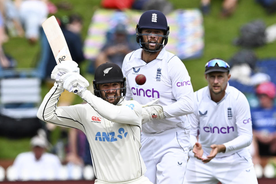 New Zealand's Tom Blundell, left, bats as England's Ben Foakes and Joe Root, right, watches on day 4 of their cricket test match in Wellington, New Zealand, Monday, Feb 27, 2023. (Andrew Cornaga/Photosport via AP)