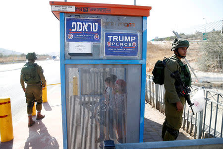 Israeli soldiers are seen next to a bus stop covered with posters from the Israeli branch of the U.S. Republican party campaign in favour of Donald Trump, near the West Bank Jewish Settlement of Ariel October 6, 2016. REUTERS/Baz Ratner/File Photo