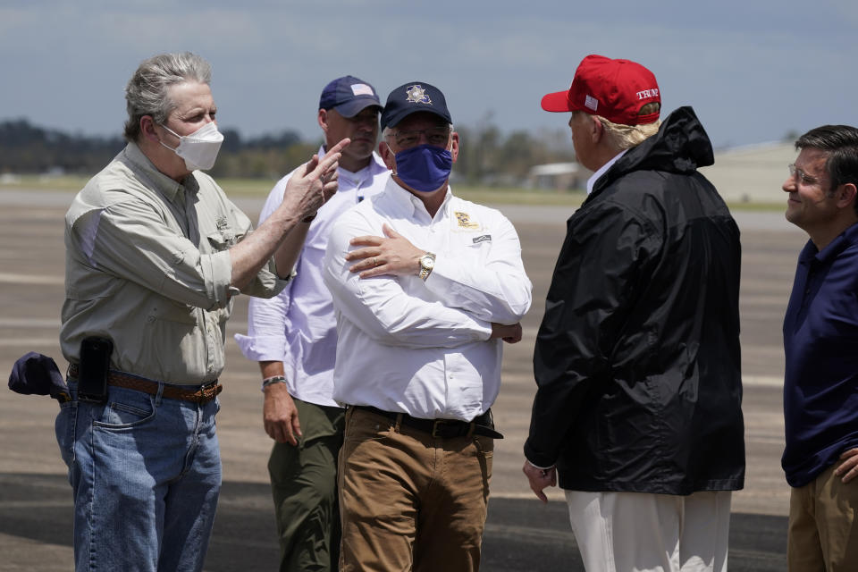 President Donald Trump talks with Sen. John Kennedy, R-La., left, and Louisiana Gov. John Bel Edwards upon arrival at Chennault International Airport, Saturday, Aug. 29, 2020, in Lake Charles, La. Trump is planning to tour damage from Hurricane Laura in Texas and Louisiana. Rep. Mike Johnson, R-La., is at far right. (AP Photo/Alex Brandon)