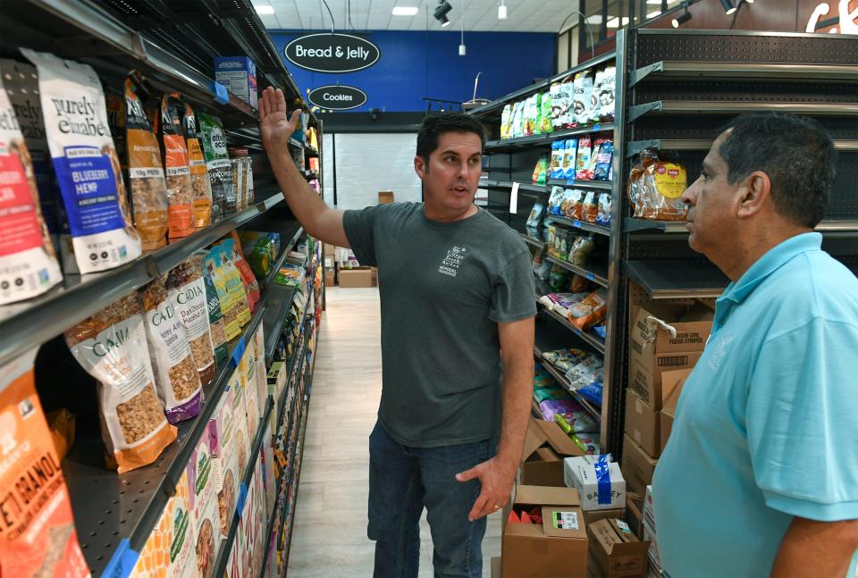 Jason Keen (left), owner of the Village Beach Market, discusses top shelf product placement with his crew member Pedro Ordonez as they work to stock the shelves on Friday, July 7, 2023, in Fort Pierce. "We picked Fort Pierce because there was a market that was already here that went out," Keen said. "We looked at it and I liked the downtown atmosphere, and I felt there was a need, and it was a great opportunity for us to grow and develop in a new market, so that's why we chose Fort Pierce."